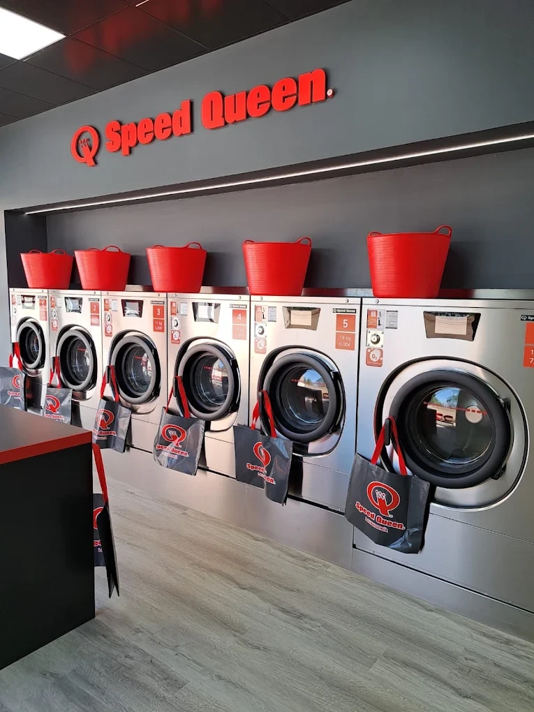 Pared de lavadoras Speed Queen con cestas rojas encima